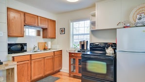 A kitchen with wooden cabinets, a microwave, a stove, and a refrigerator. - Convenient Lubbock Vacation Rental, 2 Mi to Ttu! (Lubbock)
