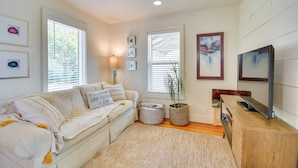 A cozy living room with a sofa, a TV, and a ceiling fan. - Convenient Lubbock Vacation Rental, 2 Mi to Ttu! (Lubbock)