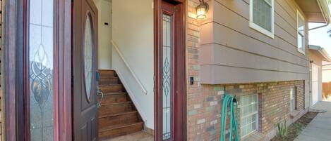 A two-story house with a front door, a staircase, and a small garden area.