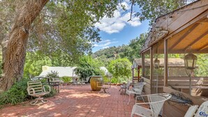 A patio area with brick flooring, metal chairs, and a wooden table. - Cozy Escondido Escape Near Hiking & Downtown! (Escondido)