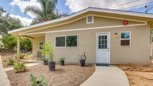 A single-story house with a beige exterior, a front door, two windows, and a covered porch area. - Cozy Escondido Escape Near Hiking & Downtown! (Escondido)