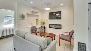 A modern living room with a sofa, chairs, a coffee table, a TV, and an air conditioning unit. - Cozy Escondido Escape Near Hiking & Downtown! (Escondido)