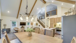 Een ruime keuken met houten kasten, een groot kookeiland en moderne apparatuur.