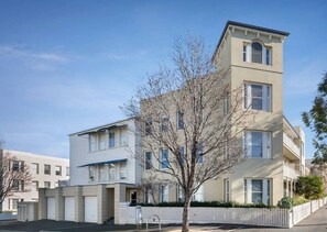 A multi-story residential building with a flat facade, a central entrance, and a small tree in the foreground. - Simply Kensington by Ready Set Stay (Kensington)