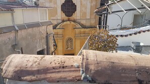 A building with a central arched doorway, a statue above it, and a metal staircase to the right. - Romantic Penthouse with Terrace - San Remo 5 minutes from the center CITRA 008055-LT-2187 (Sanremo)
