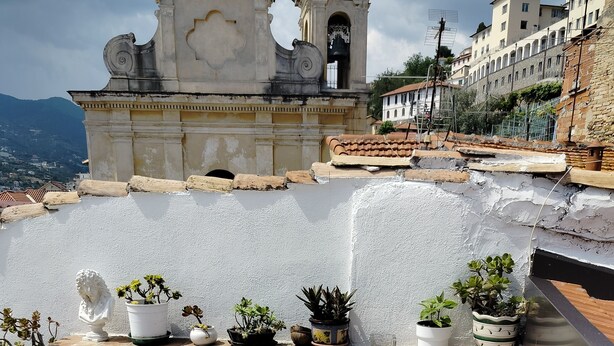 A rooftop terrace with a white sofa, a wicker table, and various potted plants. - Romantic Penthouse with Terrace - San Remo 5 minutes from the center CITRA 008055-LT-2187 (Sanremo)
