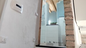 A kitchen with a brick column, white walls, and wooden beams. - Romantic Penthouse with Terrace - San Remo 5 minutes from the center CITRA 008055-LT-2187 (Sanremo)