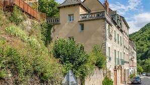 Ein mehrstöckiges Gebäude mit einer Steinfassade, einem Balkon und einer Treppe, die zu einem Holzboden führt.