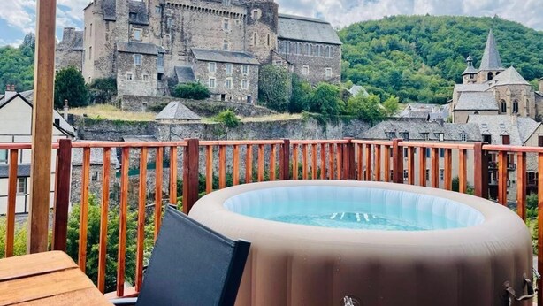Ein Whirlpool auf einer Holterrasse, im Hintergrund ein Schloss.