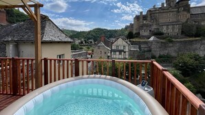 Ein Whirlpool auf einem Balkon mit Blick auf eine historische Burg.