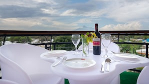 Ein Tisch für zwei, gedeckt mit einer Weinflasche, Gläsern und einem Blumenstrauß.