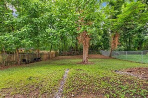 Stroll through this serene garden, surrounded by lush trees and a paved path.