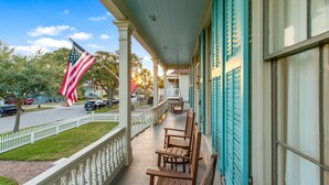 Un portico con panche di legno, una staccionata bianca e una bandiera americana.