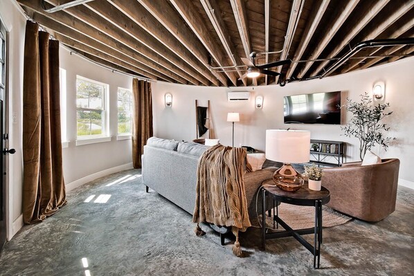 A modern living room with a sofa, a coffee table, and a TV. - HJ's Silos (Fayetteville)