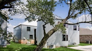 A modern building with a large tree in front. - HJ's Silos (Fayetteville)