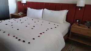Ein Hotelzimmer mit einem Bett, einem Nachttisch, einem Kleiderschrank und einer Wandlampe.