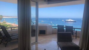 Ein Balkon mit Blick auf das Meer und Boote, ausgestattet mit einer Sitzecke inklusive Stühle und Tisch.
