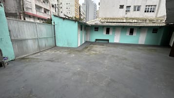 Stroll through this serene courtyard surrounded by buildings with a low wall and metal gate.