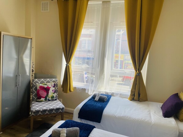 Relax in a cozy space with a comfortable bed, chair, and wardrobe, offering a convenient place to rest and unwind.