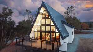 A modern house with a large deck and multiple windows. - High End A-Frame - Hot tub - Awesome Views - Yosemite - Bass Lake - EV Charger (Oakhurst)