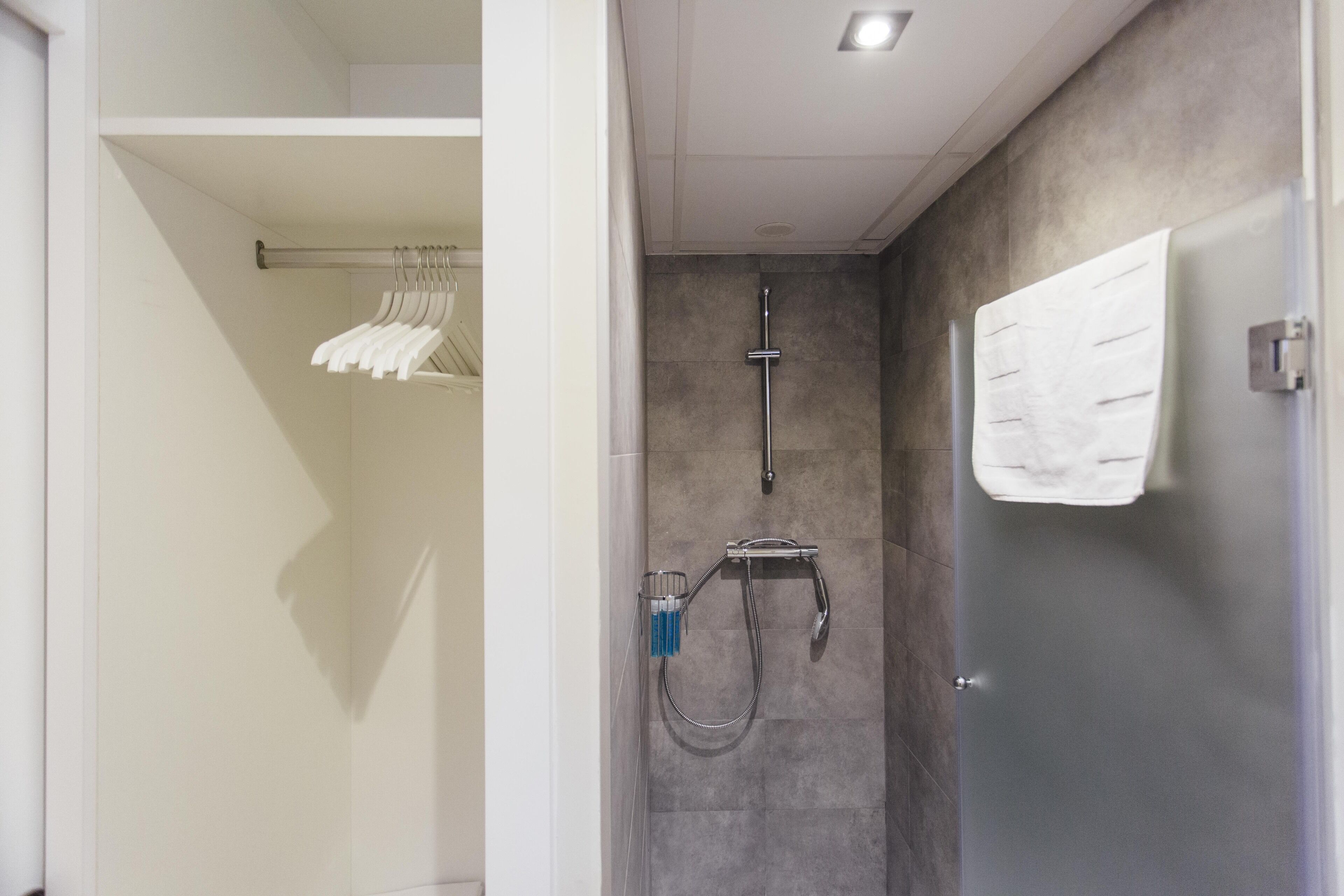 Een moderne badkamer met een inloopdouche, een handdoekhouder en een handdoek aan de muur.