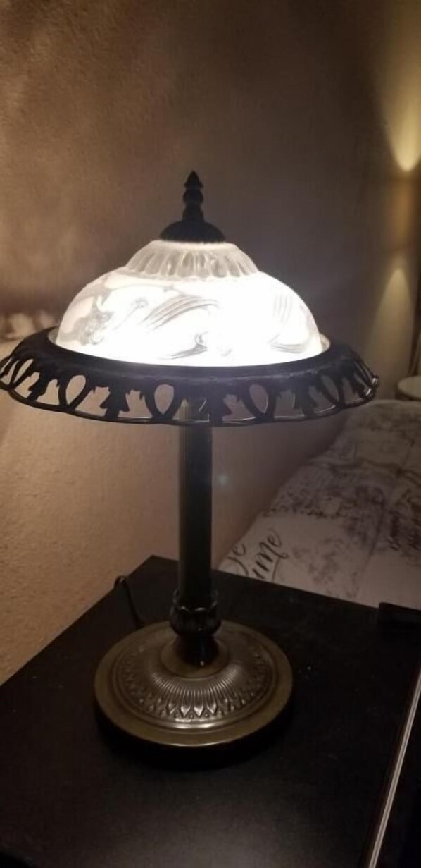 Una lámpara de mesa con pantalla decorativa y base negra.