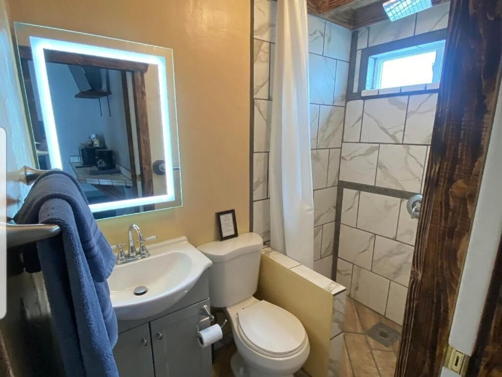 A bathroom with a sink, toilet, and shower area.