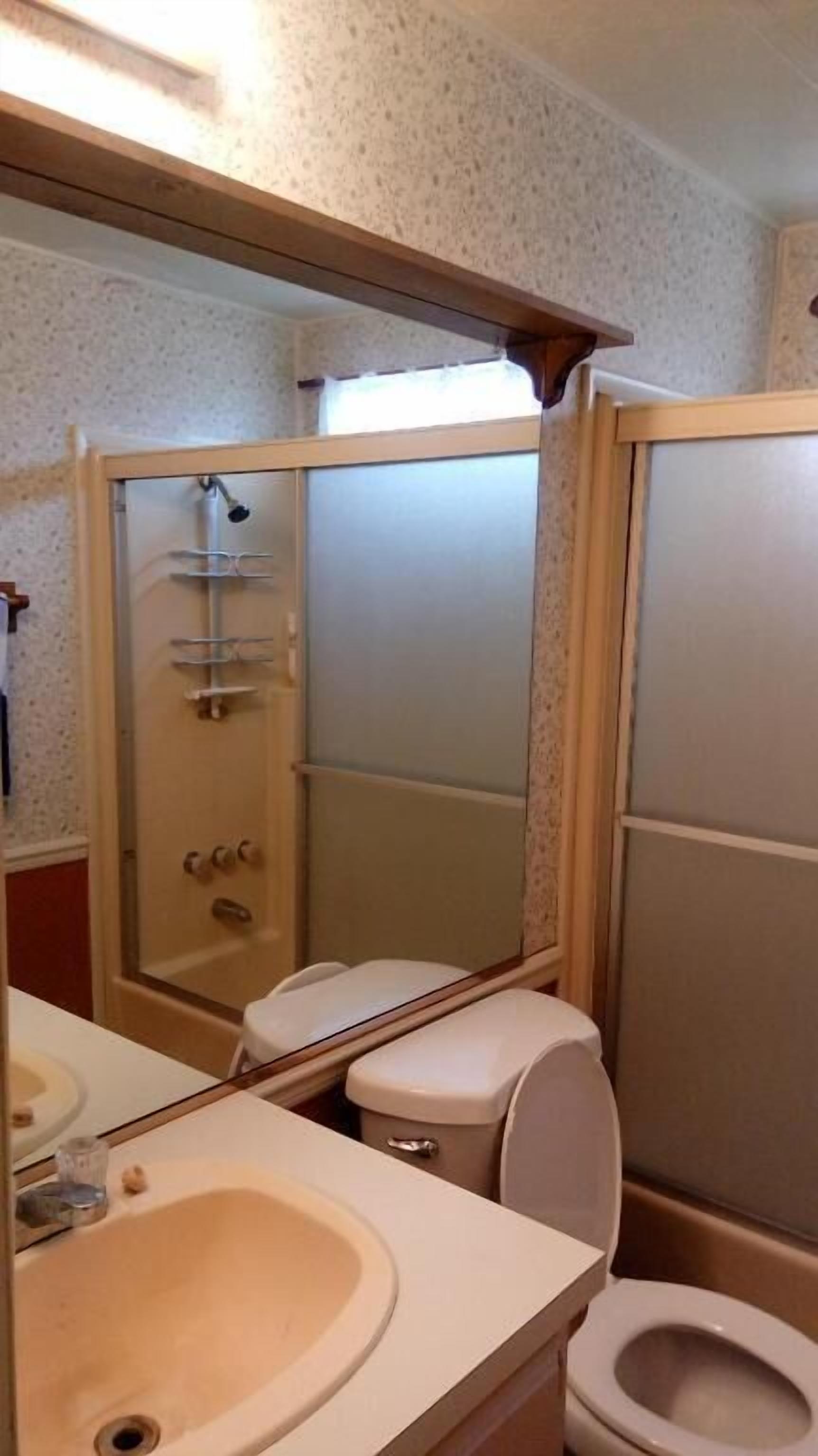 A bathroom with a toilet, sink, and shower.
