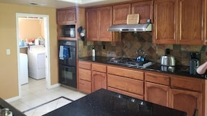 Una cocina con armarios de madera, estufa, microondas y horno empotrado.