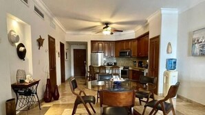 Una cocina amplia con una isla central, armarios de madera y un comedor con sillas.