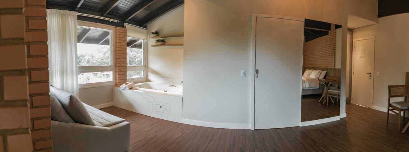 A modern room with a built-in bed, a seating area, and a small table.
