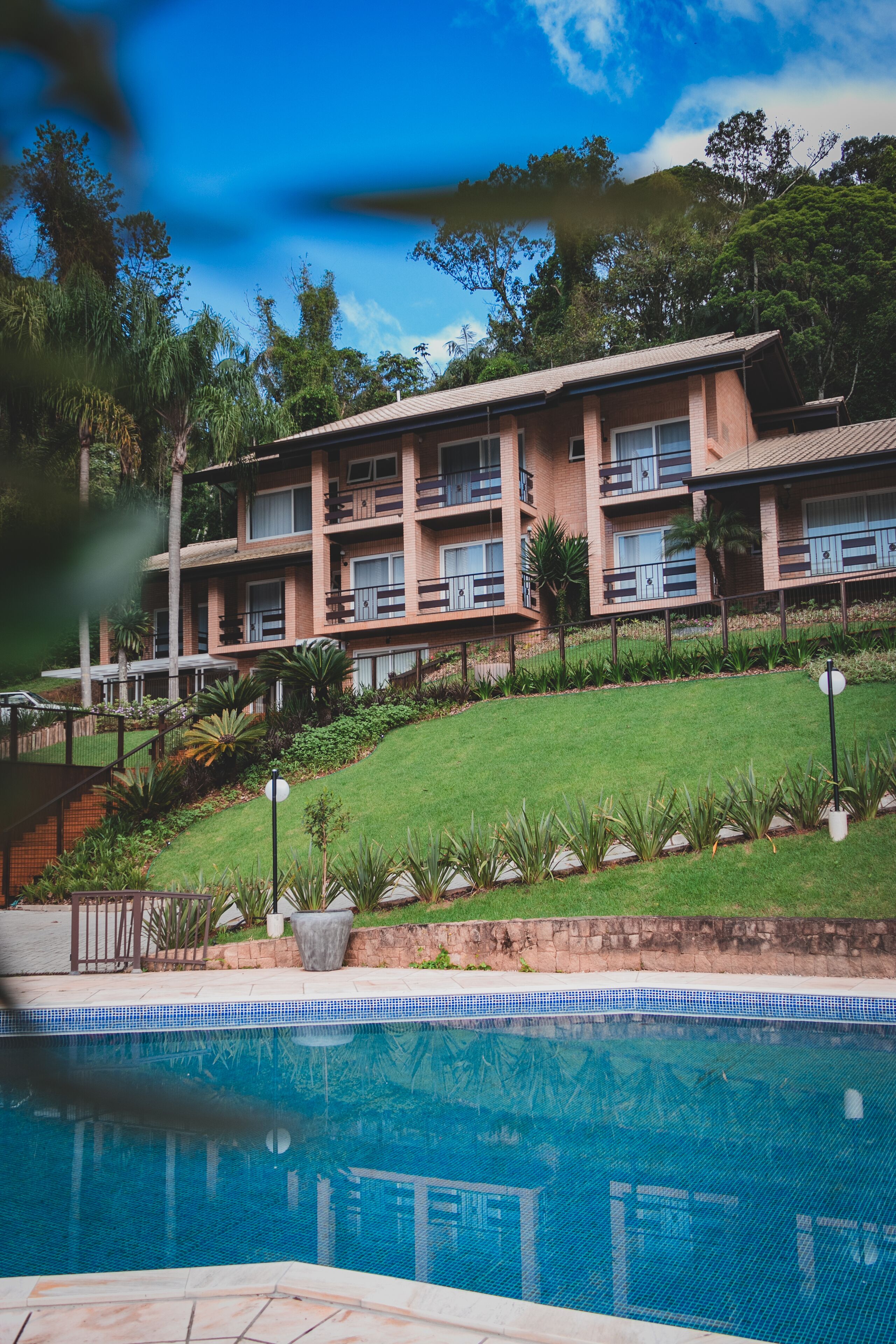 Hotel com vários andares e piscina em primeiro plano.