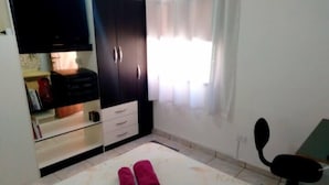 A bedroom with a bed, a wardrobe, a desk, and a chair. - Rua Anápolis (Guarulhos)