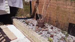 A garden with a potted plant, a stone pathway, and a fence. - Spacious chalet with furnished terrace (Fréjus)