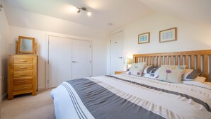 A bedroom with a bed, wooden dresser, and two framed pictures on the wall. - The Sheiling - Three Bedroom House, Sleeps 6 (Woolacombe)