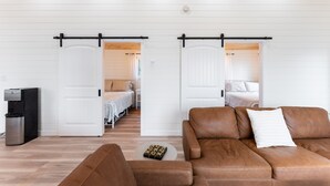 A modern interior with a brown leather sofa, a white door, and a small table with a tray.