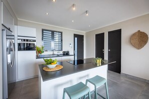 A modern kitchen with a central island, stainless steel appliances, and a minimalist design.