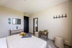 A bedroom with a bed, a bedside table, a mirror, a coat rack, and a small stool.
