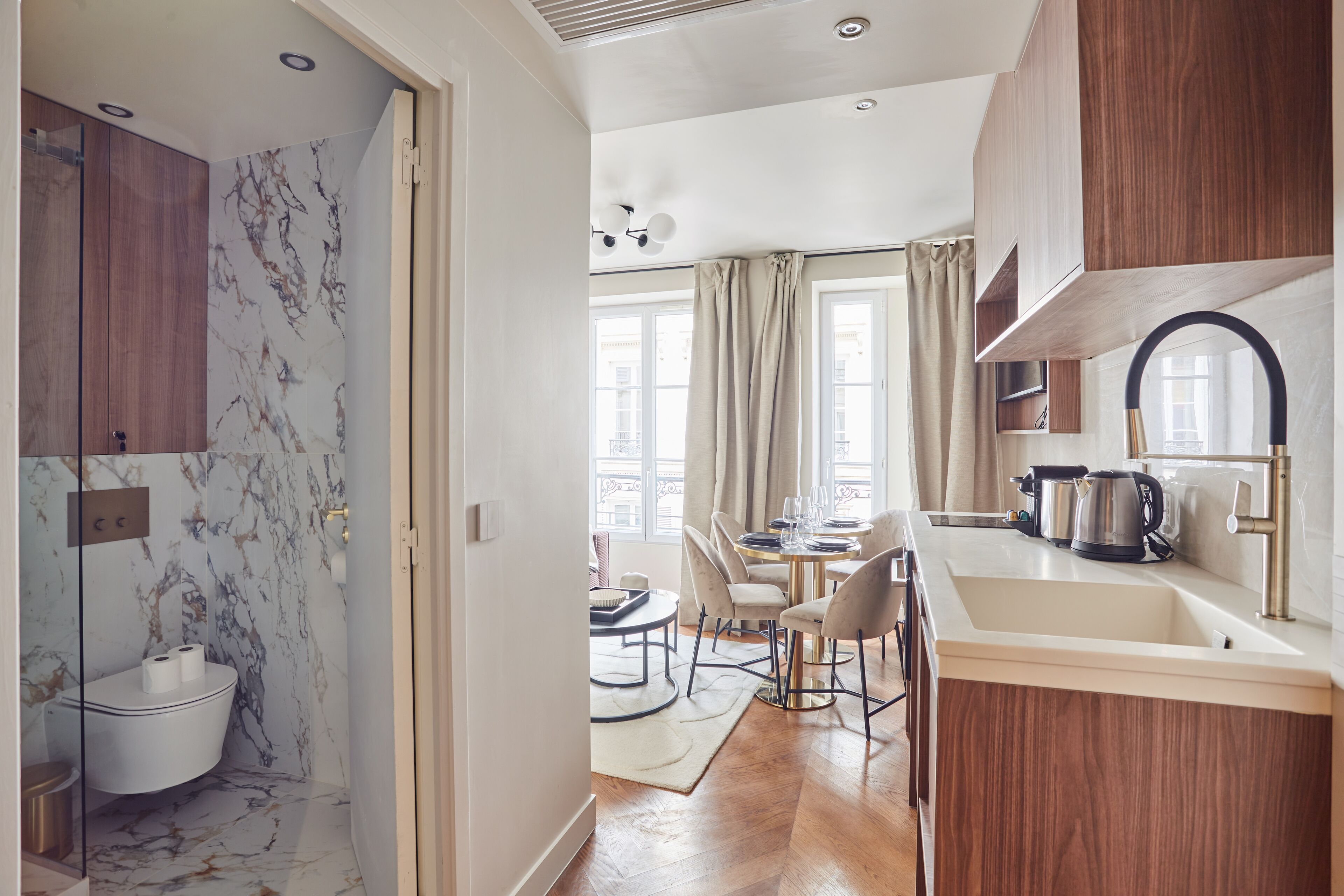 A modern kitchen with a sink, stove, and dining area.