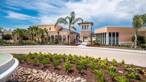 A hotel with a central courtyard, palm trees, and a clear blue sky. - Beautiful 7Bed Pool Villa with Spa and Game Room-9007PCT (Kissimmee)