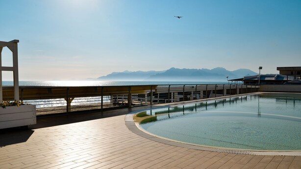A pool area with a view of the sea and mountains. - Blu Hotel  (Pontecagnano Faiano)