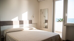 A hotel room with a bed, a large window, and a view of the sea. - Blu Hotel  (Pontecagnano Faiano)