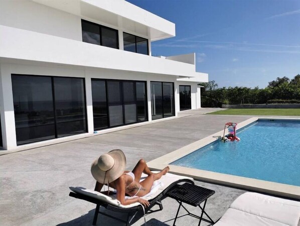 A modern house with a swimming pool, large windows, and a patio area. - Ocean Breeze Cove - Adults Only - Luxury Retreat (los destiladeros)