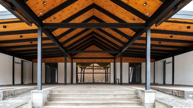A covered entrance with a wooden ceiling and metal beams, leading to two labeled doors labeled "BLOCK A" and "BLOCK B". - Gudauri Ski Resort - Twins Apartments (Kazbegi)