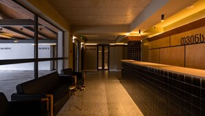 A modern lobby with a reception desk, seating area, and a view of the ski depot. - Gudauri Ski Resort - Twins Apartments (Kazbegi)
