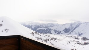 A snowy mountain landscape with a village in the valley. - Gudauri Ski Resort - Twins Apartments (Kazbegi)