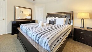 A bedroom with a bed, a ceiling fan, a bedside table with a lamp, and a dresser. - Sunny pool home with private deck - great location (Davenport)