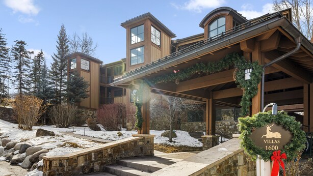 A modern building with a stone entrance and a sign reading "Villas 1600". - Condo in Snowmass Village (Snowmass Village)