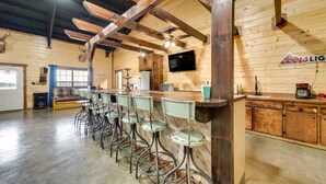 A bar area with wooden beams, a Coors Light sign, and a TV on the wall. - Pet-Friendly Eagletown Home ~ 3 Mi to Kayaking! (Eagletown)