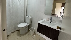 Un baño con inodoro, lavabo y espejo.